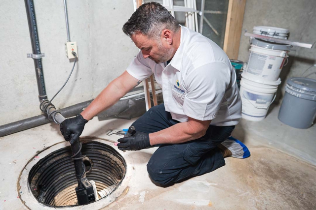 Plumber repairing a sump pump as well as installing a new one