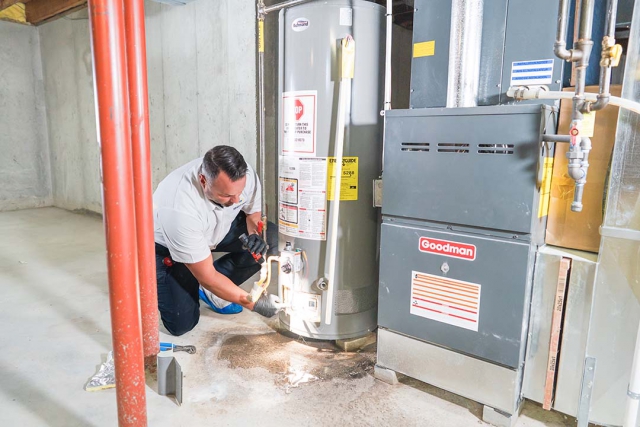 Water heater being installed by a plumber